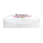 A white paper gift bag with a printed graphic on top featuring the words 'Grace and Progress!' in pink and black script, with a small gold crown and white ribbon ends, shown against a solid black background.